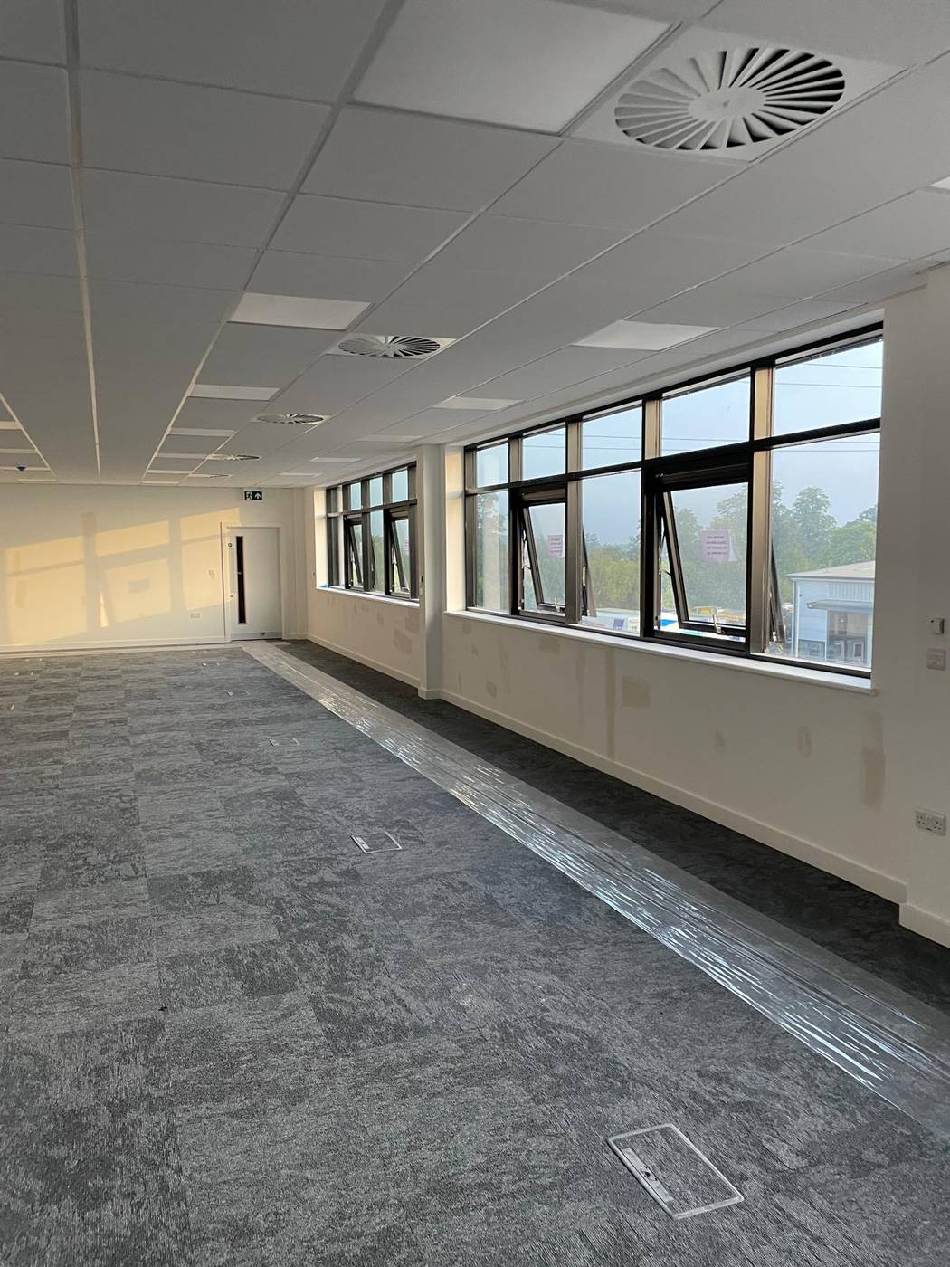 Finished office space with suspended grid ceilings and full-height glazing