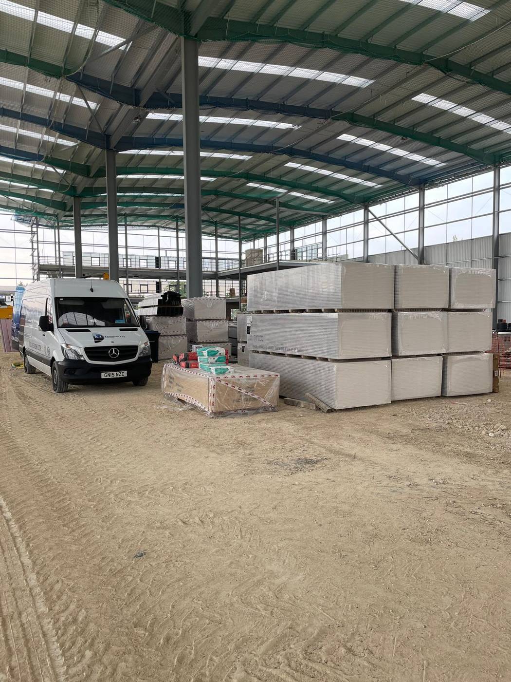 R.L. Freeman van on site beside stacked plasterboard in a new steel-frame unit